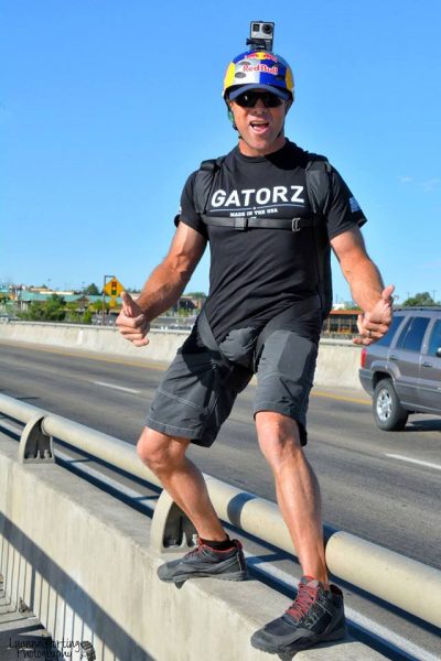 Miles Daisher stands on the guardrail of a bridge before jumping.