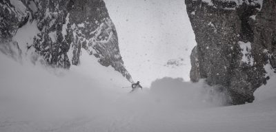 James snow skiing down a mountain in thick snow.