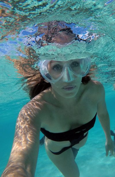 Roberta Mancino swimming in azure water.