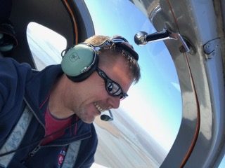 Marcus smiling while piloting an aircraft.