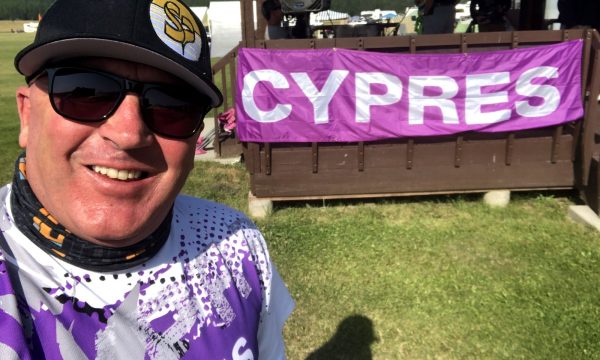 Regan Tetlow smiles in front of a CYPRES banner