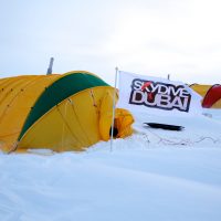 Photo of a yellow tent surrounded by deep snow in the Himalayas