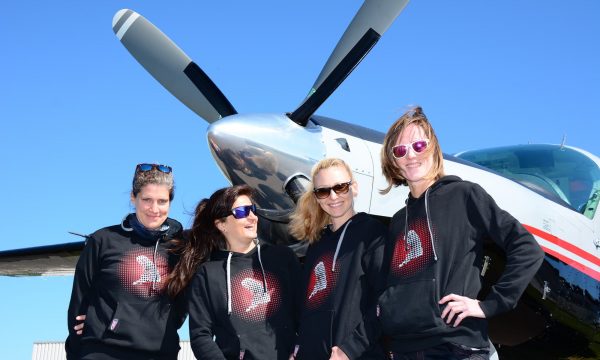 A team photo of Team Skynamite in front of an airplane