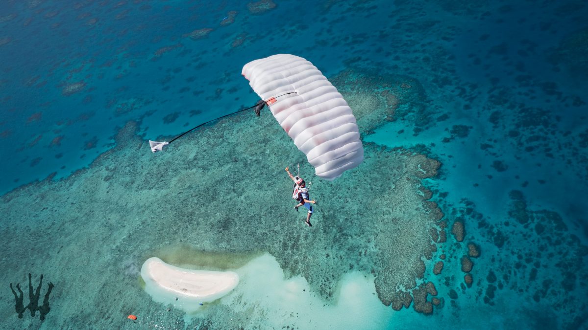 Photo above a small white sand island in the middle of the ocean