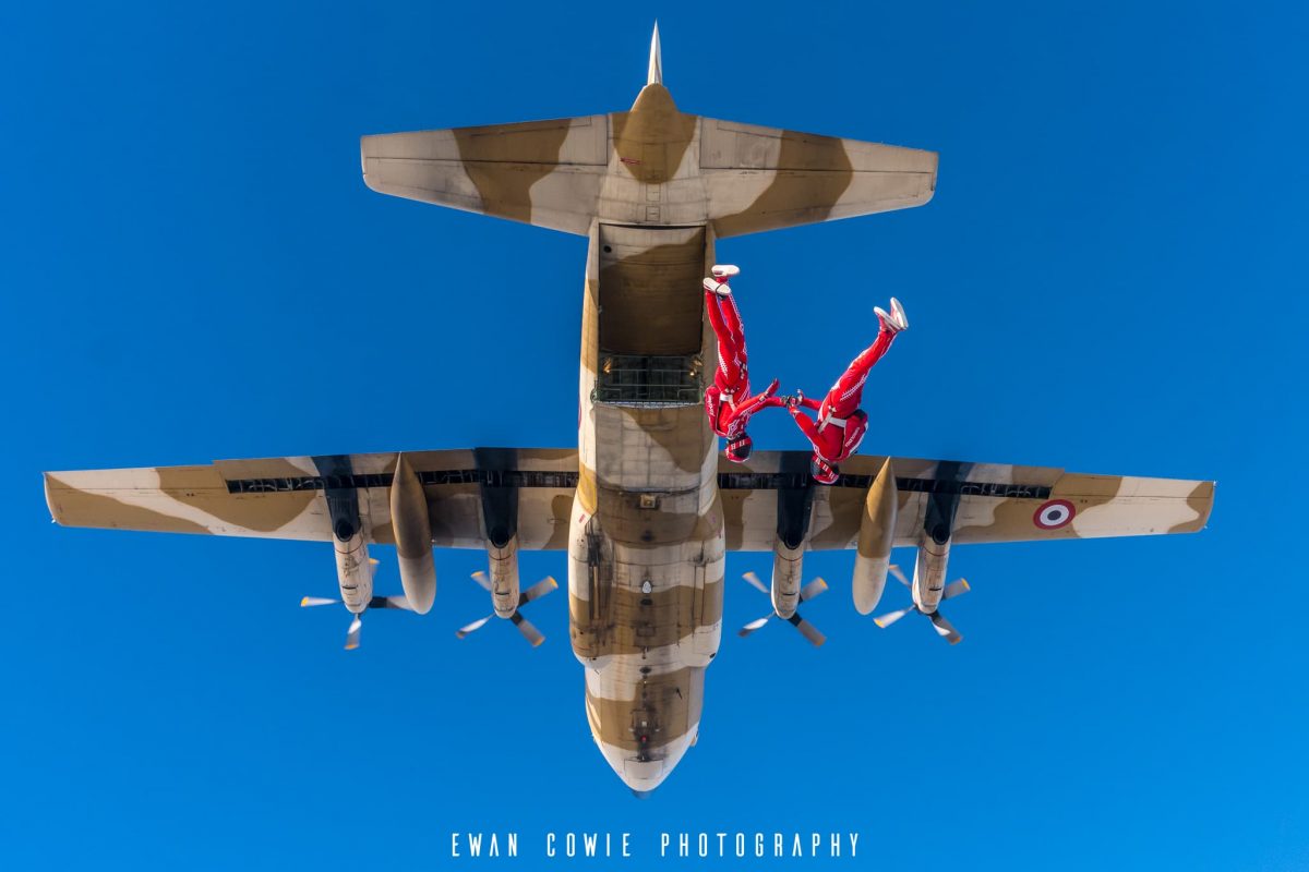 Team Airwax photographed in free fall with a Hercules C-130 in the background