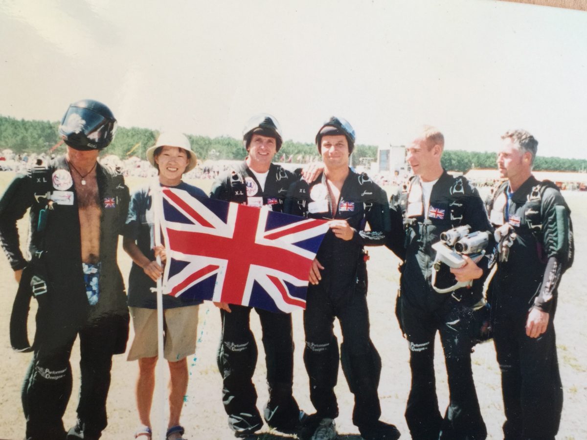 The British Skydiving Team with Pete Allum smiles while wearing their jumpsuits and holding the Union Jack