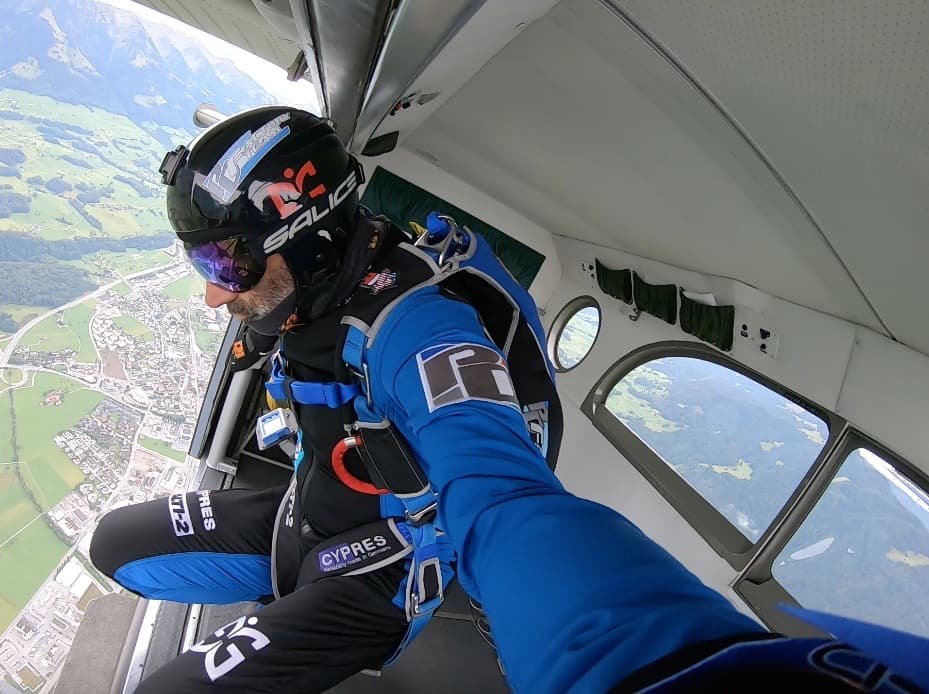 Vito in the door of a plane looking down moments away from jumping. 