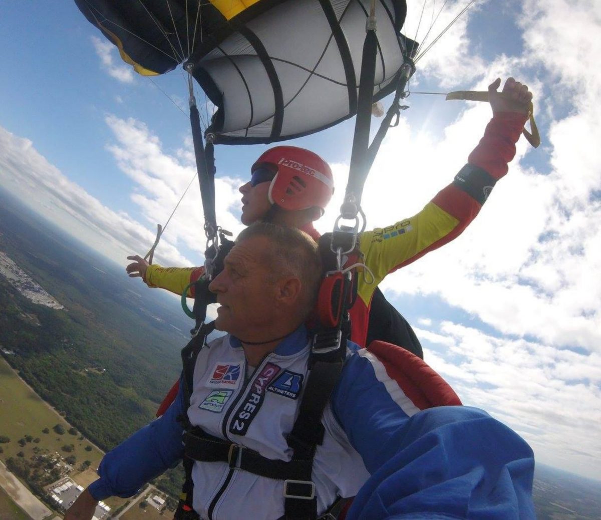 Bram rides as a tandem passenger as one of his students steers the parachute as tandem instructor