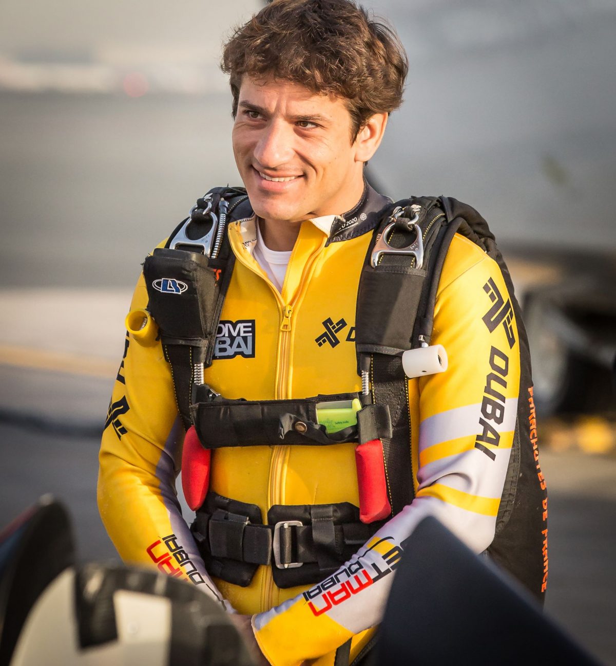 Fred Fugen smiles while wearing a yellow JetMan jumpsuit