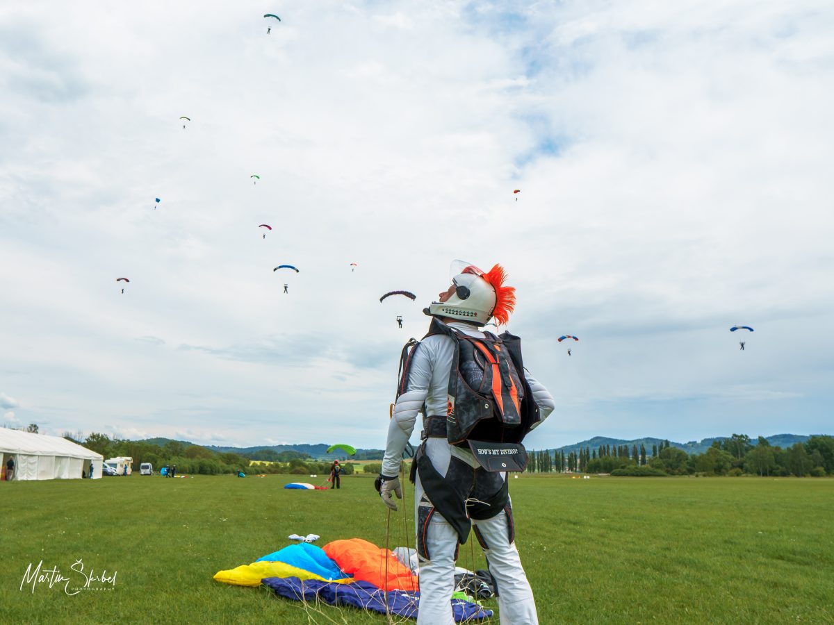 Brian Cumming looks up at the sky while wearing his skydiving kit after a jump